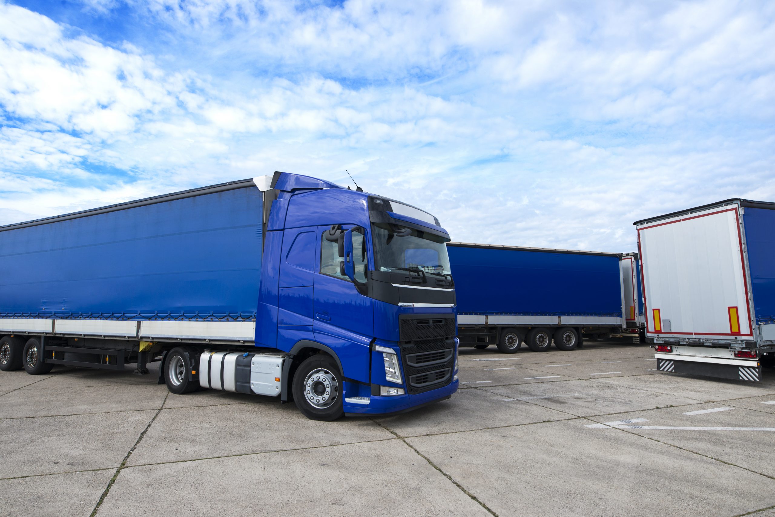 Blue truck vehicle with trailers in background