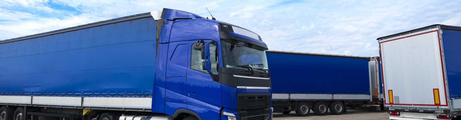 Blue truck vehicle with trailers in background